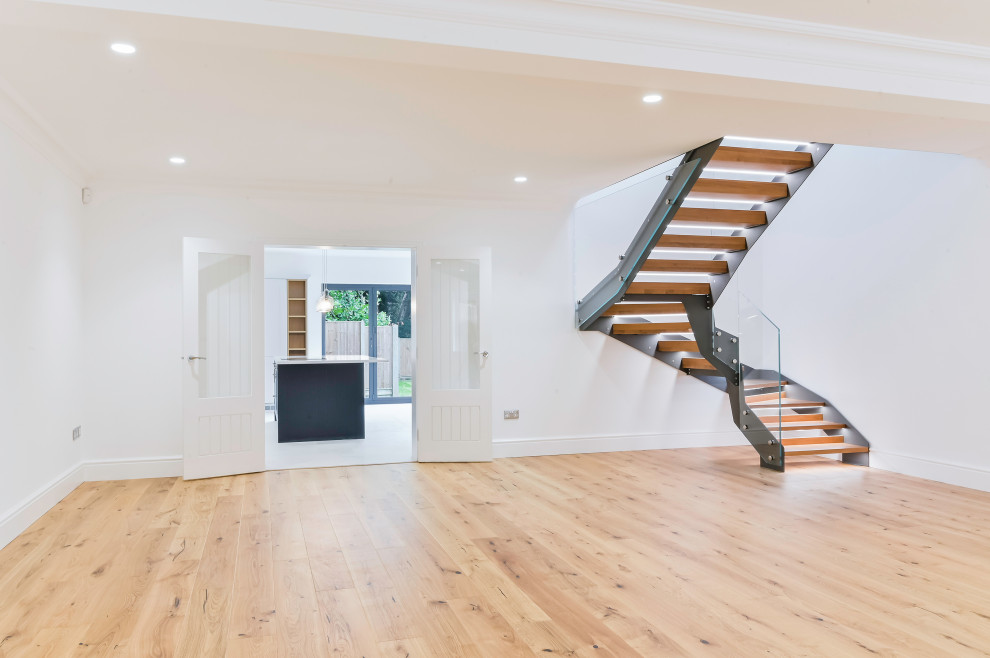 Свежая идея для дизайна: п-образная лестница среднего размера в стиле модернизм с деревянными ступенями и стеклянными перилами без подступенок - отличное фото интерьера