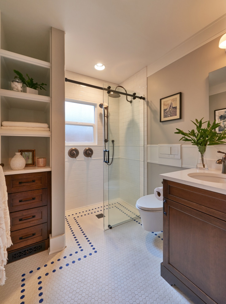 Design ideas for a small transitional bathroom in Seattle with shaker cabinets, medium wood cabinets, a curbless shower, a wall-mount toilet, white tile, beige walls, ceramic floors, an undermount sink, engineered quartz benchtops, white floor, a sliding shower screen, white benchtops, a single vanity and a built-in vanity.