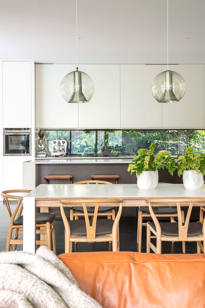 Photo of a contemporary kitchen in Melbourne with glass sheet splashback and with island.