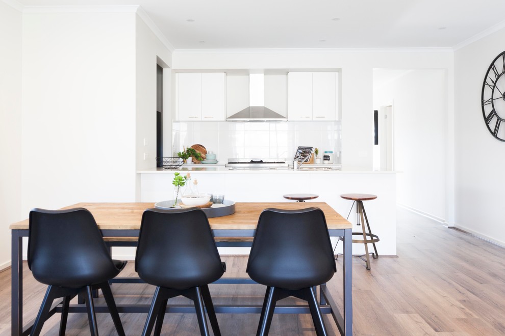 Contemporary open plan dining in Melbourne with white walls, medium hardwood floors and brown floor.