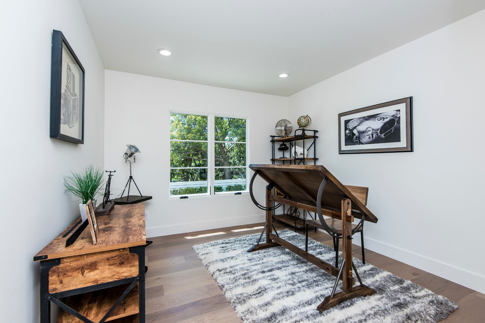 Photo of a country home studio in Los Angeles with white walls, dark hardwood floors and a freestanding desk.