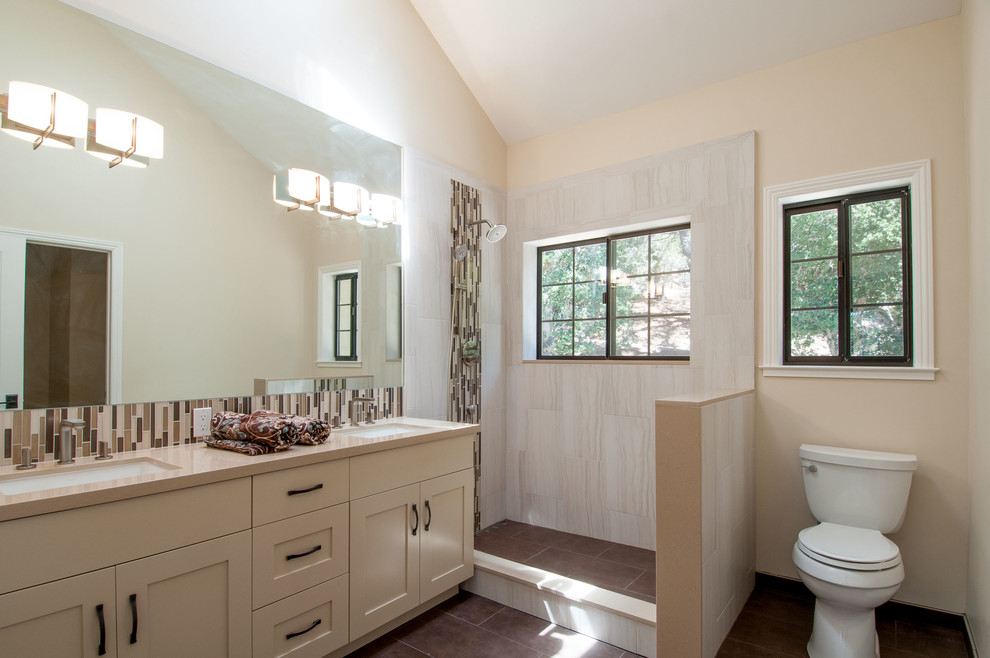 Photo of a transitional bathroom in San Francisco with an undermount sink, shaker cabinets, beige cabinets, quartzite benchtops, a corner shower, a one-piece toilet, multi-coloured tile and glass tile.
