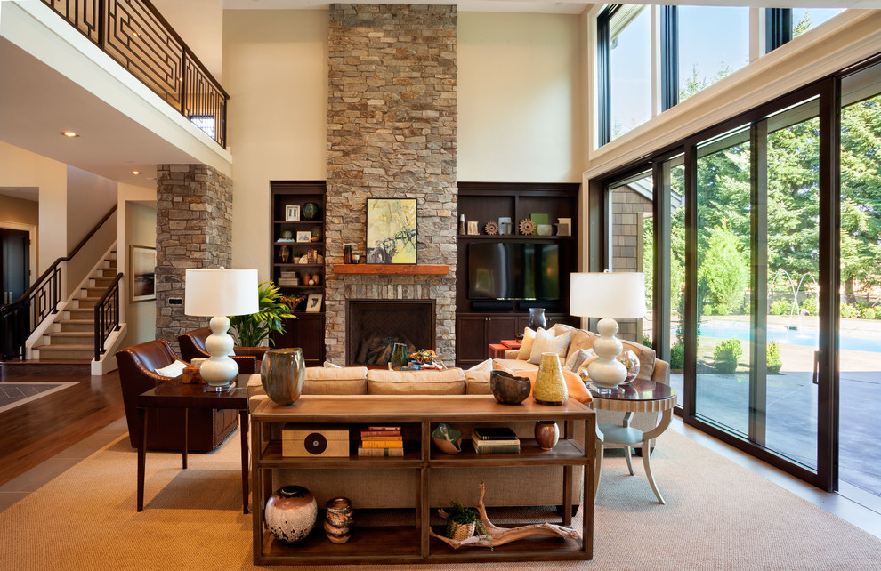 Photo of an expansive transitional open concept living room in Portland with a stone fireplace surround, beige walls, carpet, a built-in media wall and a standard fireplace.