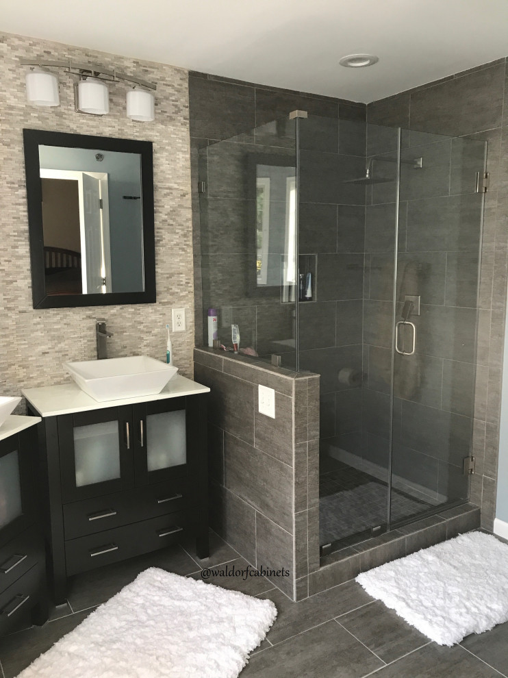 Photo of a mid-sized modern 3/4 bathroom in DC Metro with beaded inset cabinets, dark wood cabinets, a corner shower, a one-piece toilet, beige tile, ceramic tile, a vessel sink, marble benchtops, a hinged shower door, white benchtops, a double vanity and a freestanding vanity.