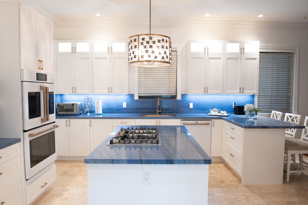 Mid-sized traditional u-shaped eat-in kitchen in Miami with an undermount sink, shaker cabinets, white cabinets, blue splashback, white appliances, with island and blue benchtop.