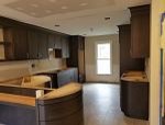 Inspiration for a large transitional l-shaped porcelain tile and beige floor eat-in kitchen remodel with a farmhouse sink, shaker cabinets, black cabinets, quartz countertops, blue backsplash, ceramic backsplash, stainless steel appliances, a peninsula and white countertops