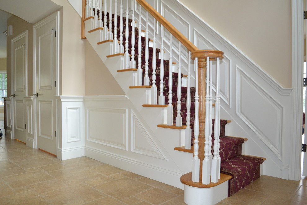 This is an example of a mid-sized traditional wood straight staircase in New York with painted wood risers and wood railing.