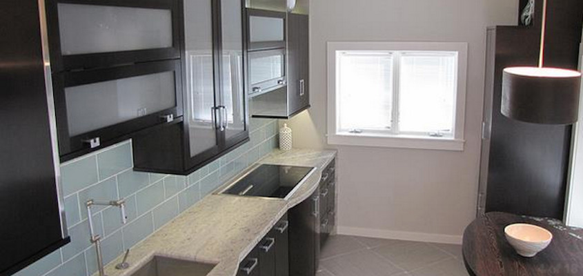 Inspiration for a ceramic tile eat-in kitchen remodel with a farmhouse sink, glass-front cabinets, dark wood cabinets, granite countertops, blue backsplash and stainless steel appliances