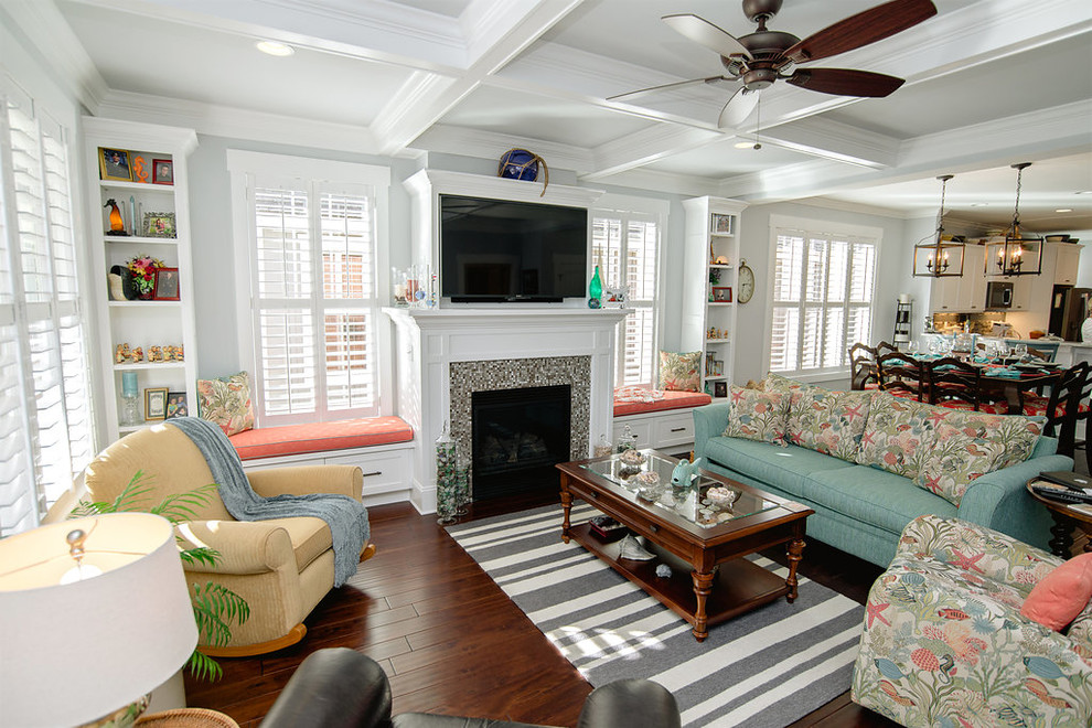 Photo of a mid-sized beach style living room in Other with blue walls, dark hardwood floors, a standard fireplace, a tile fireplace surround and a wall-mounted tv.