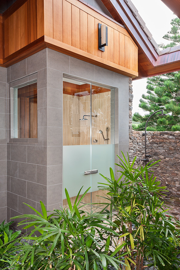 Inspiration for a large tropical 3/4 bathroom in Hawaii with an open shower, gray tile, grey walls and a hinged shower door.