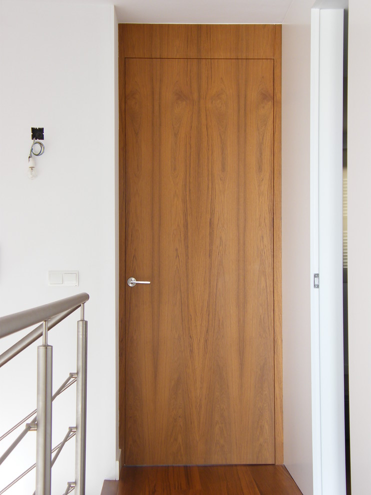 Diseño de puerta principal clásica renovada pequeña con paredes blancas, suelo de madera en tonos medios, puerta simple y puerta de madera en tonos medios