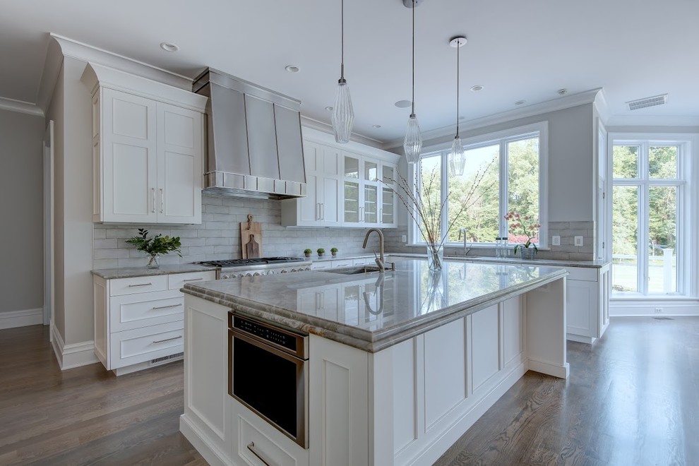 Design ideas for a large contemporary u-shaped eat-in kitchen in DC Metro with an undermount sink, shaker cabinets, white cabinets, limestone benchtops, grey splashback, subway tile splashback, stainless steel appliances, light hardwood floors, with island, beige floor and grey benchtop.