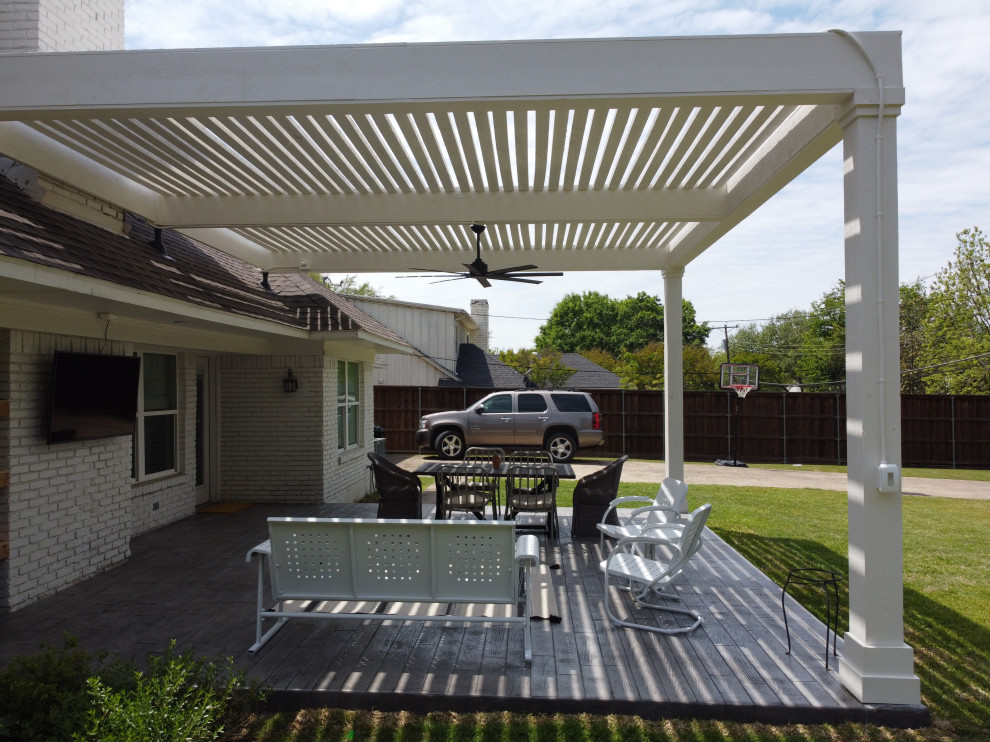 Design ideas for a large modern backyard patio in Dallas with stamped concrete and a pergola.