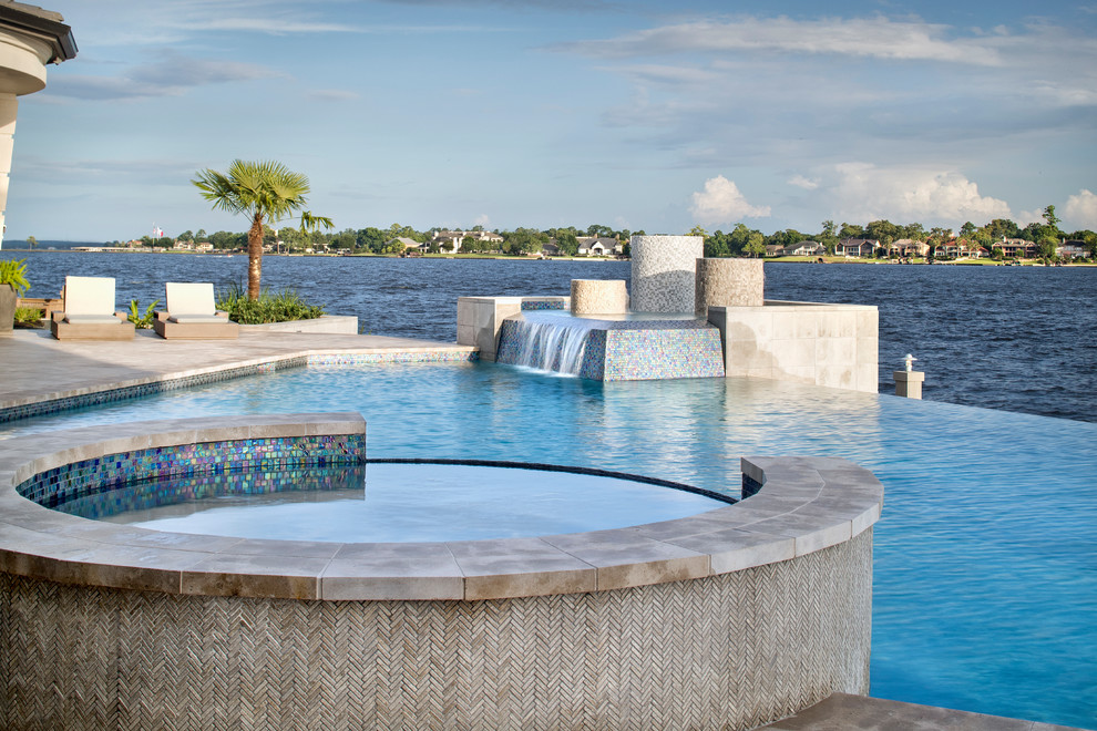 Design ideas for an expansive beach style backyard custom-shaped infinity pool in Houston with a water feature.