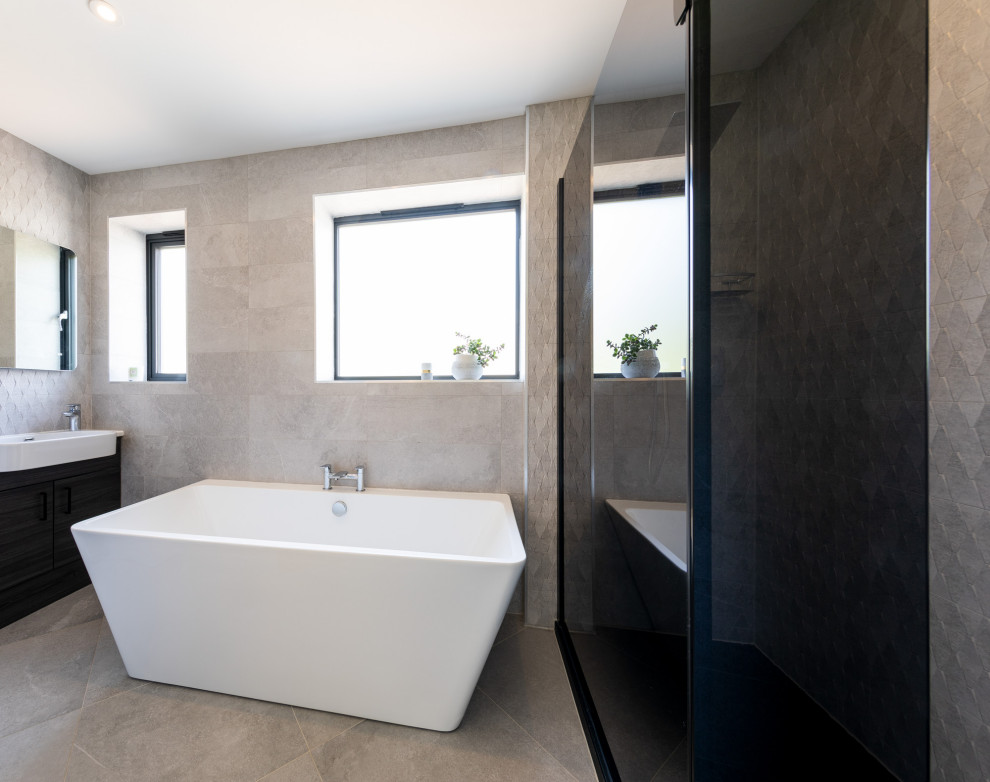 Photo of a medium sized contemporary family bathroom in Other with shaker cabinets, black cabinets, a freestanding bath, an alcove shower, grey tiles, cement tiles, grey walls, cement flooring, a trough sink, solid surface worktops, grey floors, white worktops, feature lighting, a single sink, a built in vanity unit and panelled walls.