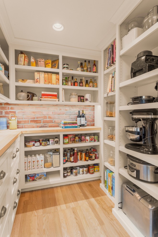 Transitional u-shaped kitchen pantry in Seattle with open cabinets, white cabinets, brick splashback, light hardwood floors, no island and beige floor.