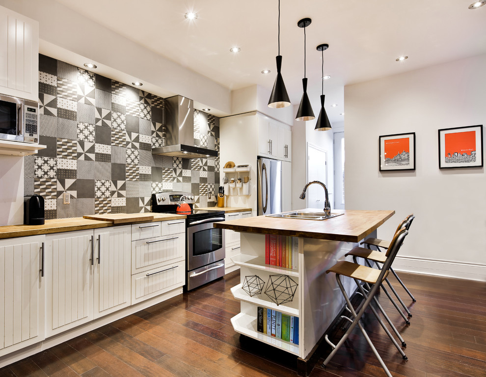 Inspiration for a contemporary kitchen in Montreal with a drop-in sink, white cabinets, multi-coloured splashback, stainless steel appliances, dark hardwood floors and with island.