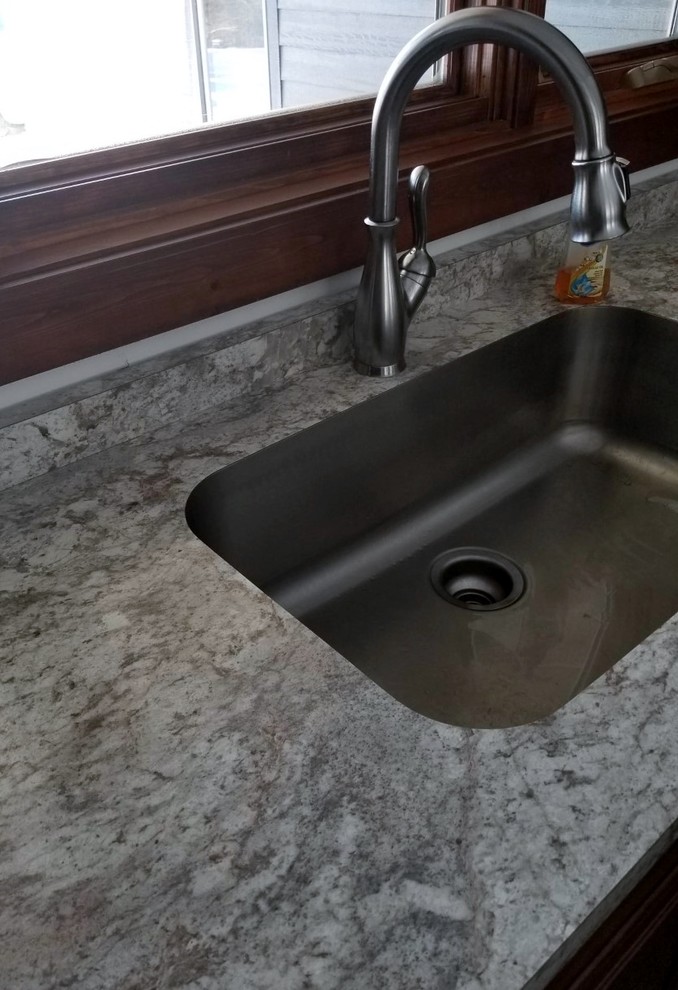Transitional u-shaped kitchen photo with an undermount sink, shaker cabinets, laminate countertops, stainless steel appliances and an island