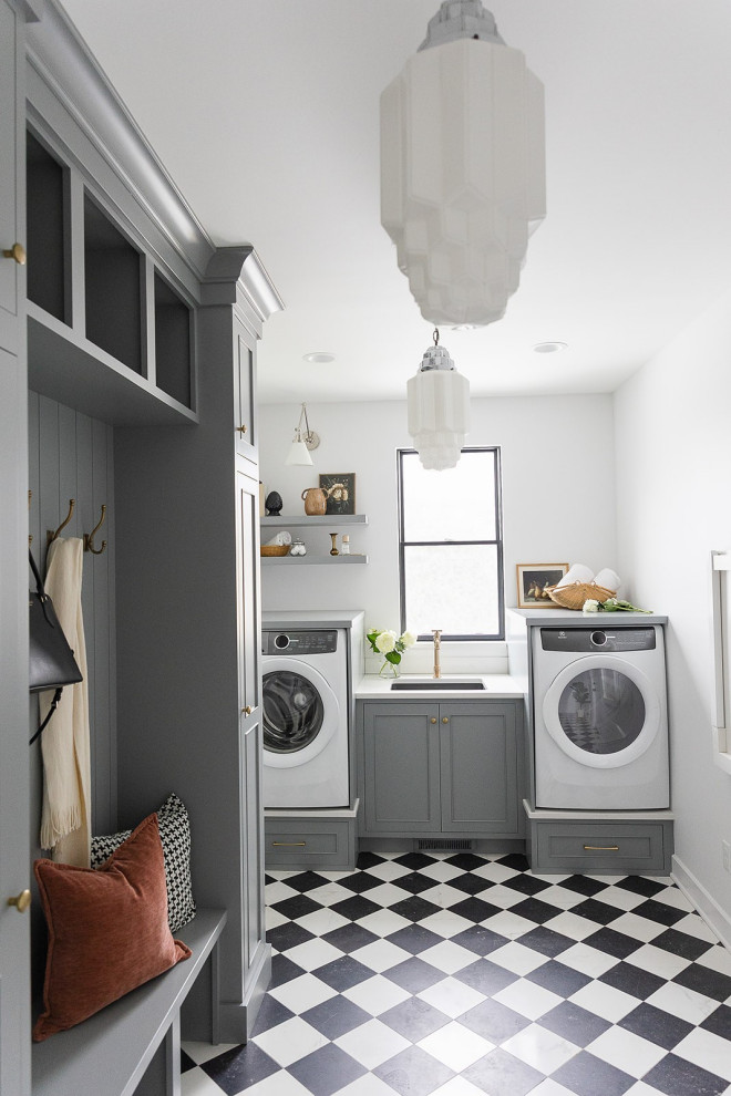 Foto på en stor vintage vita tvättstuga med garderob, med en undermonterad diskho, grå skåp, bänkskiva i kvarts, vitt stänkskydd, vita väggar och klinkergolv i porslin