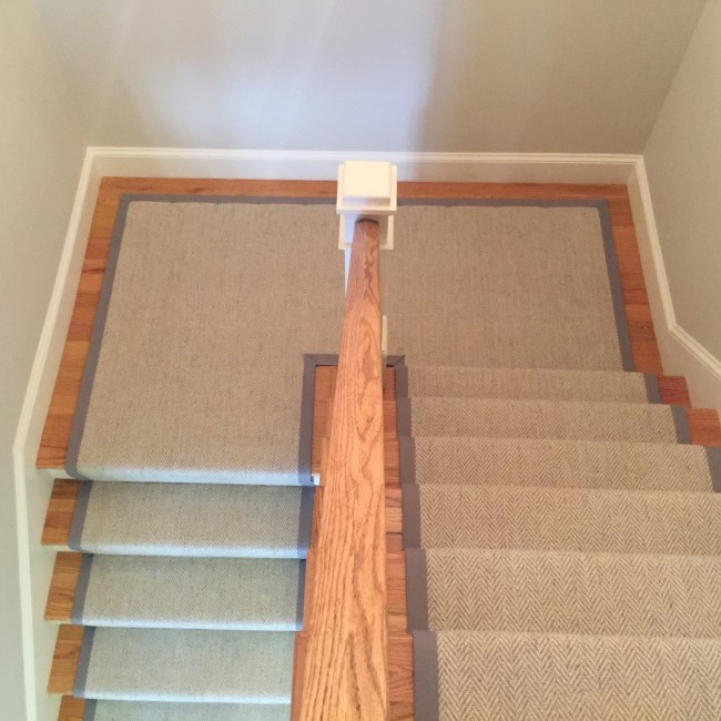Photo of a large modern carpeted u-shaped staircase in Chicago with carpet risers and wood railing.