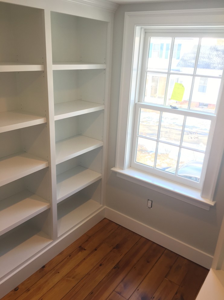 Inspiration for a small country walk-in wardrobe in Bridgeport with recessed-panel cabinets, white cabinets and medium hardwood floors.