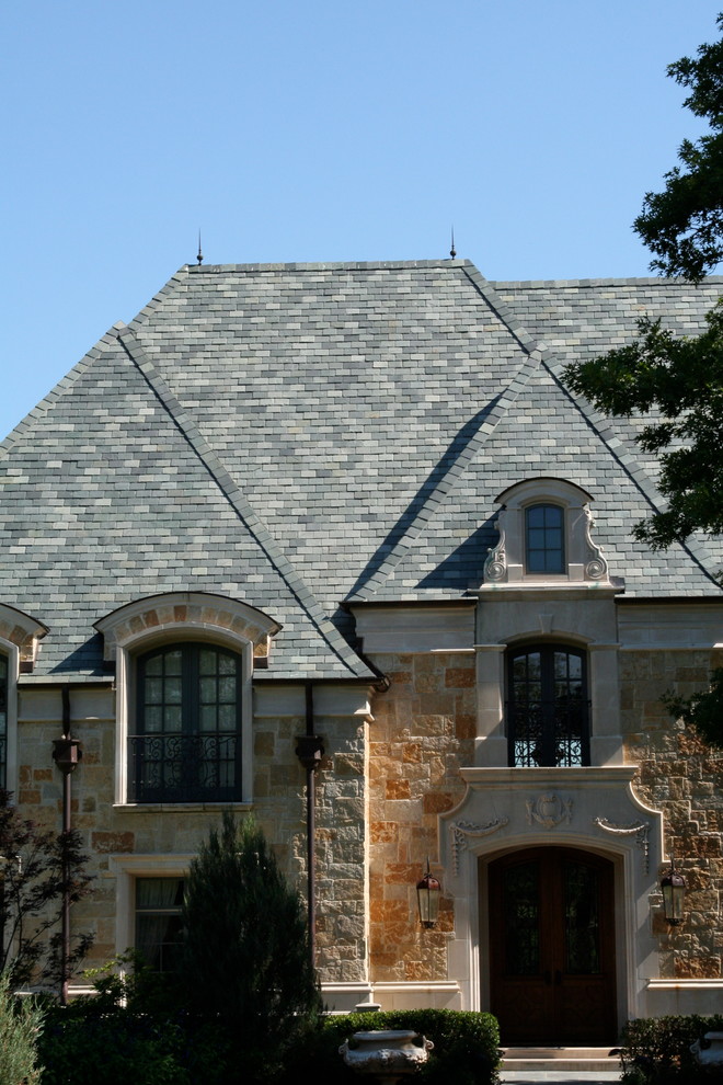 Inspiration for a large traditional two-storey beige house exterior in Dallas with stone veneer, a hip roof and a shingle roof.