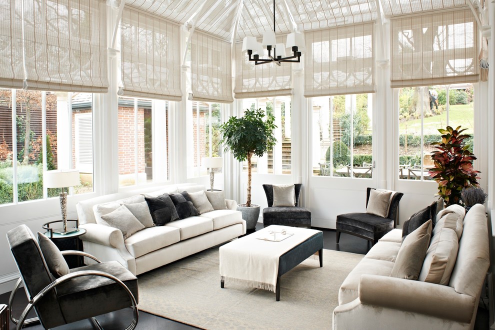 This is an example of a transitional sunroom in London with no fireplace, a glass ceiling and grey floor.