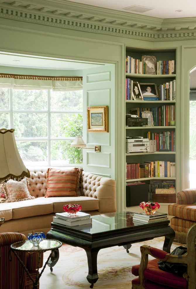 This is an example of a traditional enclosed living room in Other with a library and green walls.