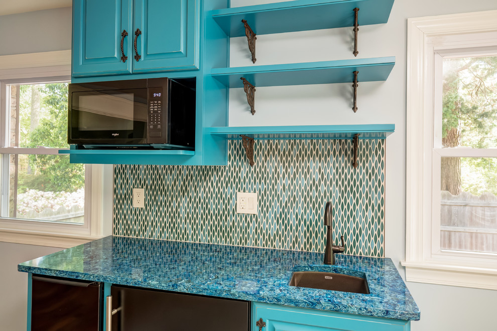Small traditional single-wall wet bar in Other with medium hardwood floors, brown floor, raised-panel cabinets, blue cabinets, blue benchtop, an undermount sink, quartz benchtops, blue splashback and glass tile splashback.
