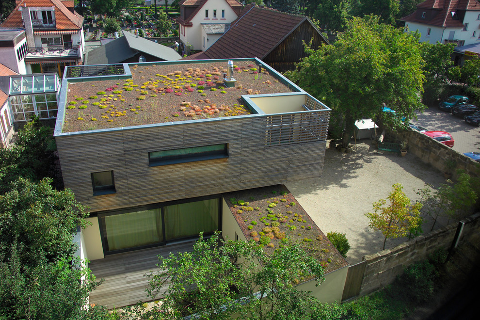 This is an example of a contemporary two-storey brown exterior in Nuremberg with wood siding and a shed roof.