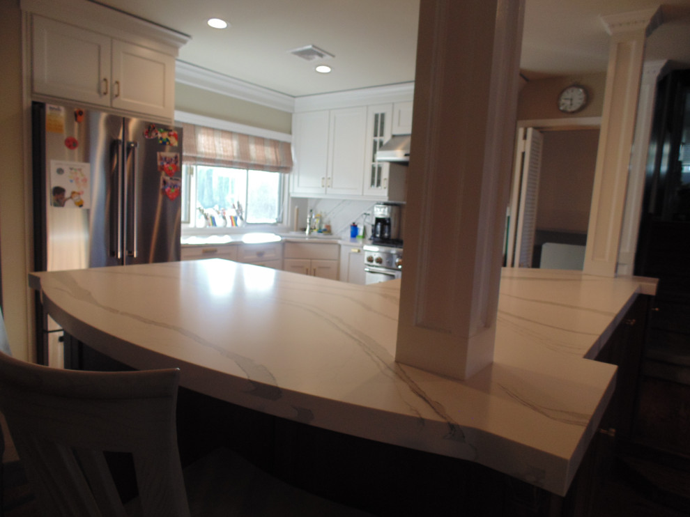 Eat-in kitchen - mid-sized transitional u-shaped medium tone wood floor and brown floor eat-in kitchen idea with an undermount sink, recessed-panel cabinets, white cabinets, quartz countertops, white backsplash, stone slab backsplash, stainless steel appliances, no island and white countertops