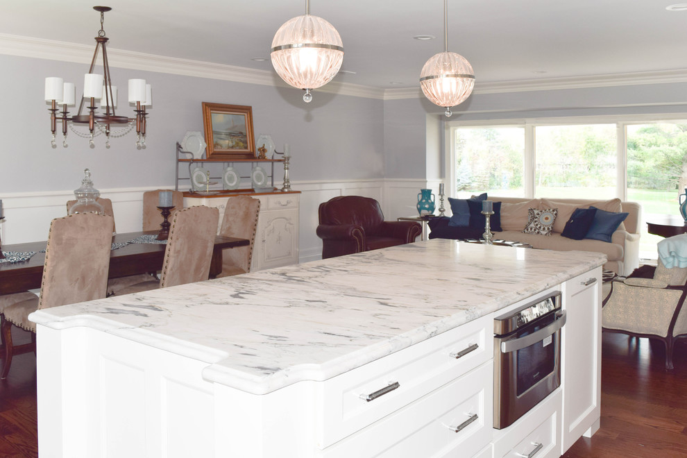 Eat-in kitchen - mid-sized coastal l-shaped dark wood floor eat-in kitchen idea in New York with a farmhouse sink, recessed-panel cabinets, white cabinets, marble countertops, metallic backsplash, mosaic tile backsplash, stainless steel appliances and an island