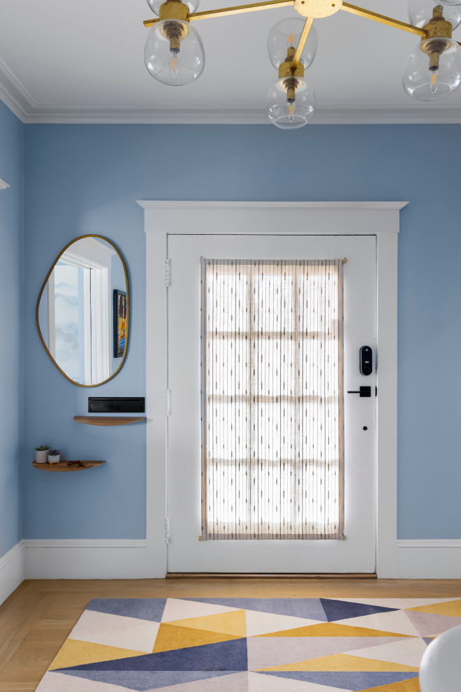 Ispirazione per una porta d'ingresso tradizionale di medie dimensioni con pareti blu, parquet chiaro, una porta singola, una porta bianca e pavimento beige