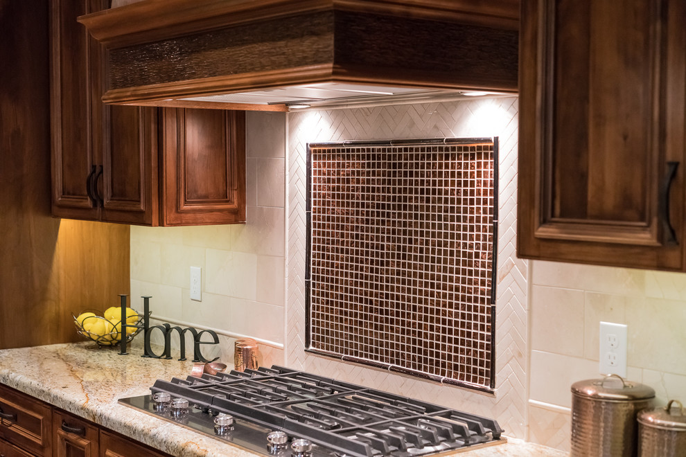 Mid-sized mountain style l-shaped medium tone wood floor and brown floor open concept kitchen photo in Minneapolis with a single-bowl sink, raised-panel cabinets, medium tone wood cabinets, granite countertops, beige backsplash, stone tile backsplash, black appliances and an island