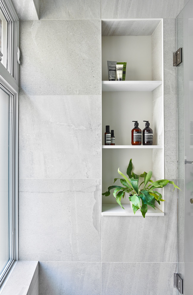This is an example of a mid-sized 3/4 bathroom in Toronto with gray tile, grey walls, a hinged shower door and an alcove shower.