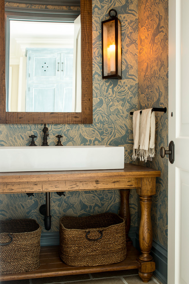 This is an example of a traditional powder room in New York with furniture-like cabinets, medium wood cabinets, multi-coloured walls, a vessel sink, wood benchtops and brown benchtops.