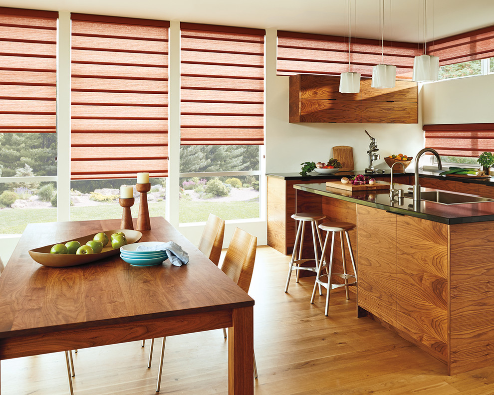 Example of a mid-sized mountain style u-shaped medium tone wood floor eat-in kitchen design with a drop-in sink, flat-panel cabinets, medium tone wood cabinets, quartz countertops and an island