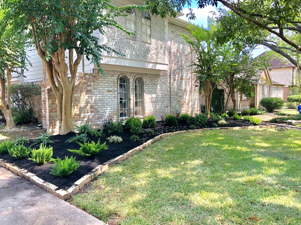 This is an example of a mid-sized eclectic front yard partial sun garden in Houston.