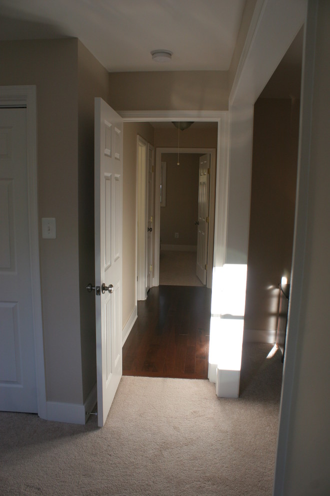 Example of a mid-sized minimalist dark wood floor hallway design in Baltimore with beige walls