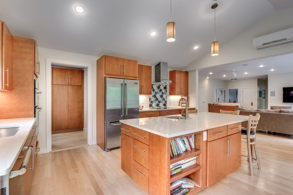 Large contemporary l-shaped eat-in kitchen in Boston with an undermount sink, flat-panel cabinets, light wood cabinets, white splashback, subway tile splashback, stainless steel appliances, light hardwood floors, with island, quartz benchtops and beige floor.