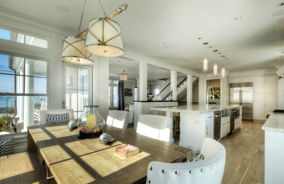 Example of a large transitional single-wall light wood floor and beige floor open concept kitchen design in Providence with a farmhouse sink, beaded inset cabinets, white cabinets, granite countertops, beige backsplash, mosaic tile backsplash, stainless steel appliances and an island