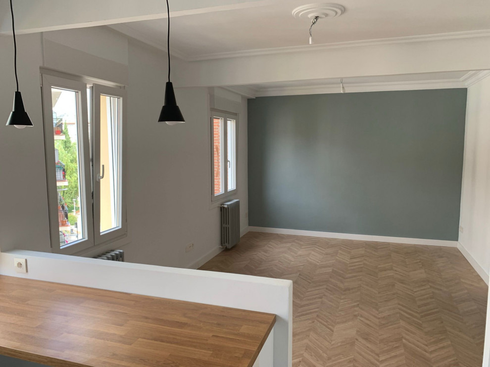 Cette photo montre une salle de séjour tendance de taille moyenne et ouverte avec un bar de salon, un mur vert, sol en stratifié, un sol marron et un plafond à caissons.