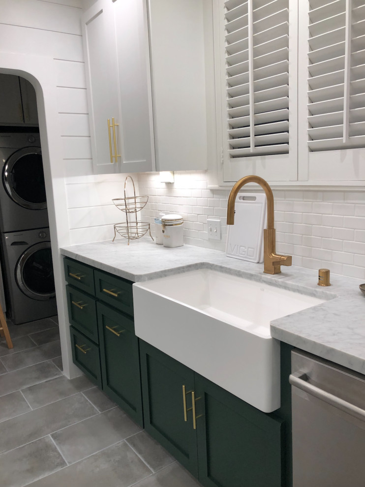 Modern inredning av ett mellanstort vit vitt kök, med en rustik diskho, släta luckor, gröna skåp, marmorbänkskiva, vitt stänkskydd, stänkskydd i keramik, rostfria vitvaror, cementgolv och grått golv