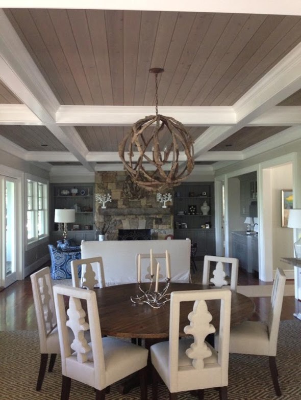 Large mountain style dark wood floor and brown floor kitchen/dining room combo photo with beige walls, a standard fireplace and a stone fireplace