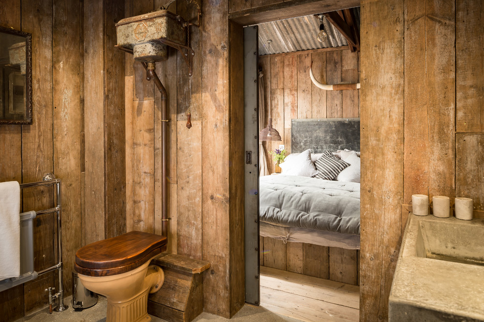 Country master bathroom in Cornwall with a drop-in tub, a corner shower, concrete floors, a trough sink and concrete benchtops.