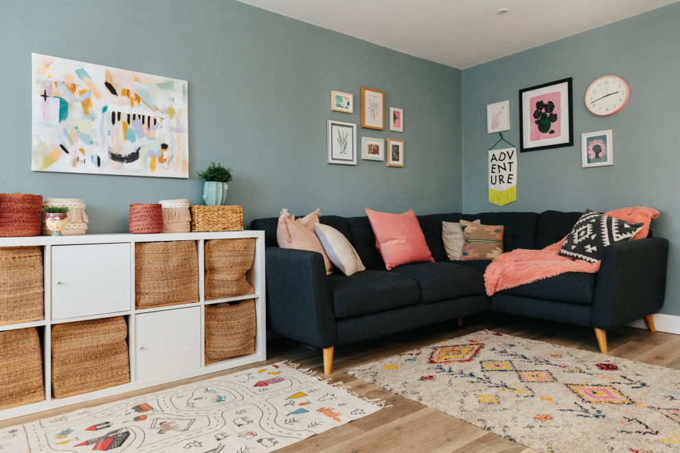 Medium sized scandinavian living room in London with blue walls, light hardwood flooring and beige floors.