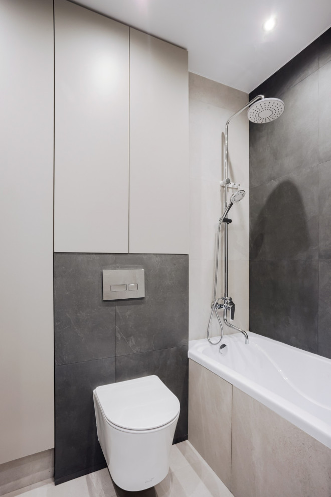 Inspiration för mellanstora moderna grått en-suite badrum, med släta luckor, grå skåp, ett platsbyggt badkar, en dusch/badkar-kombination, en vägghängd toalettstol, grå kakel, klinkergolv i keramik, ett fristående handfat, grått golv och med dusch som är öppen