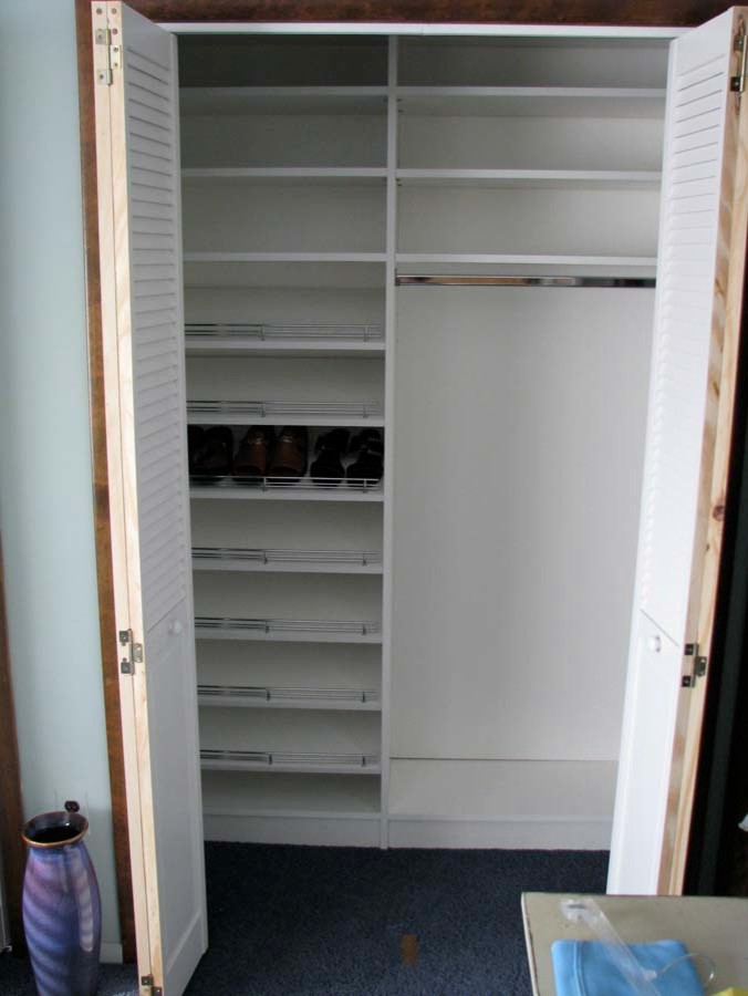 Photo of a mid-sized transitional gender-neutral built-in wardrobe in New York with white cabinets and light hardwood floors.