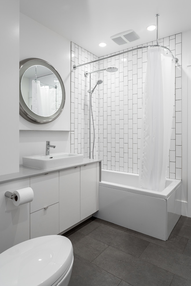 Inspiration for a mid-sized contemporary 3/4 bathroom in Seattle with a vessel sink, flat-panel cabinets, white cabinets, solid surface benchtops, a shower/bathtub combo, a two-piece toilet, white tile, subway tile, white walls, porcelain floors and a drop-in tub.