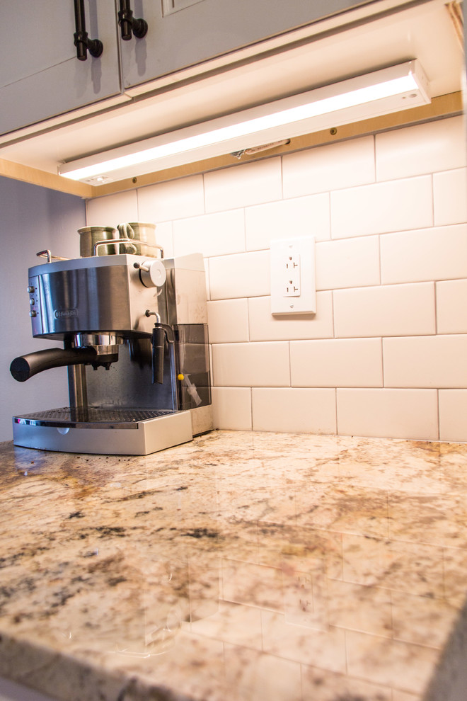 Transitional medium tone wood floor kitchen photo with granite countertops, subway tile backsplash and stainless steel appliances